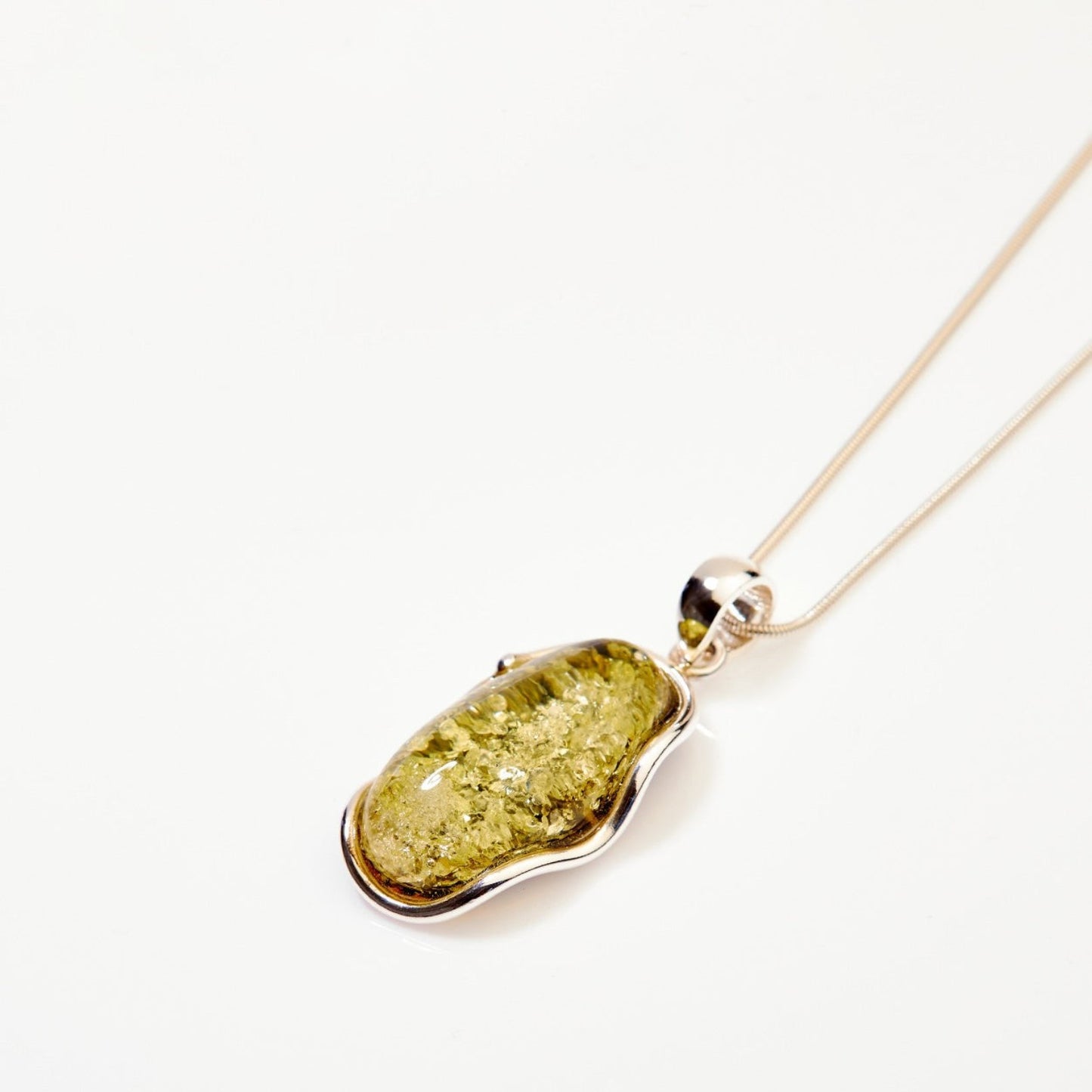 Gold pendant with a green stone on a white background