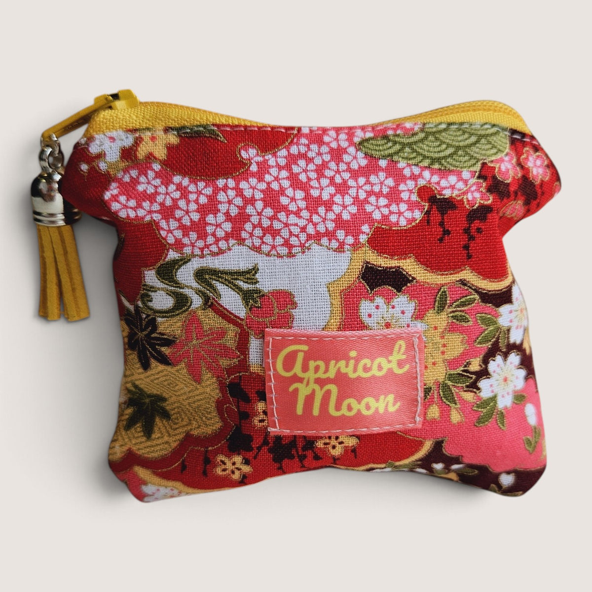Isumi Red Japanese purse with a yellow zip and tassel, showing the Apricot Moon label