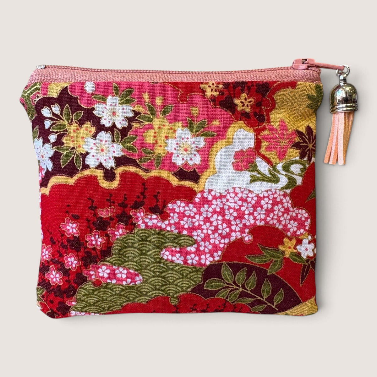 Front of the Isumi Red Japanese purse in a red and pink cherry blossom print with a pink zip and peach tassel