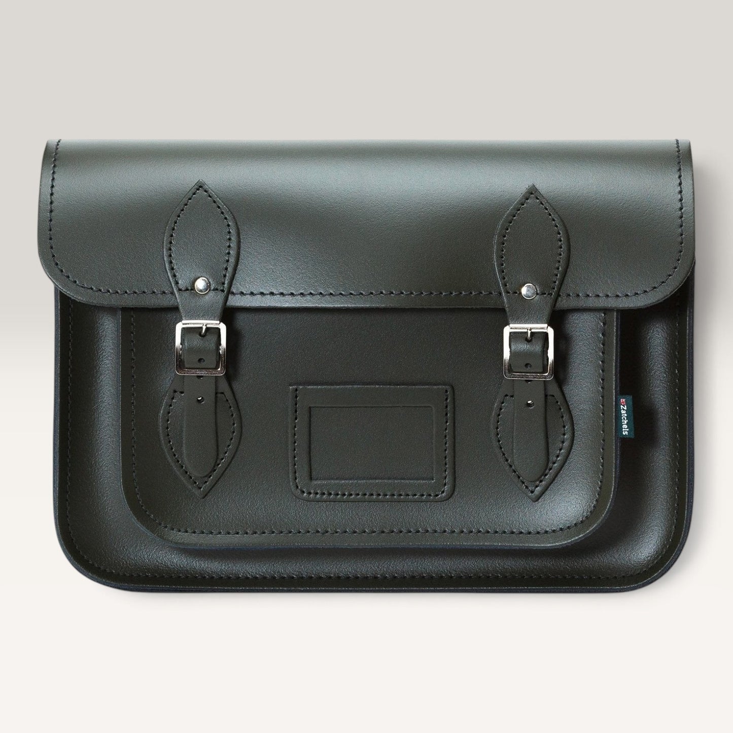 A dark green leather satchel bag with two buckle straps and silver metal hardware, shown against a light gray background.