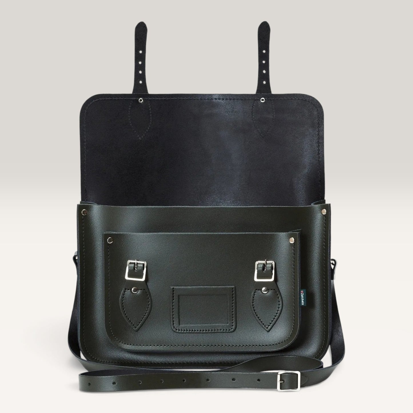 A black leather messenger bag with a front pocket, silver buckle details, and a detachable shoulder strap, shown against a neutral light gray background.