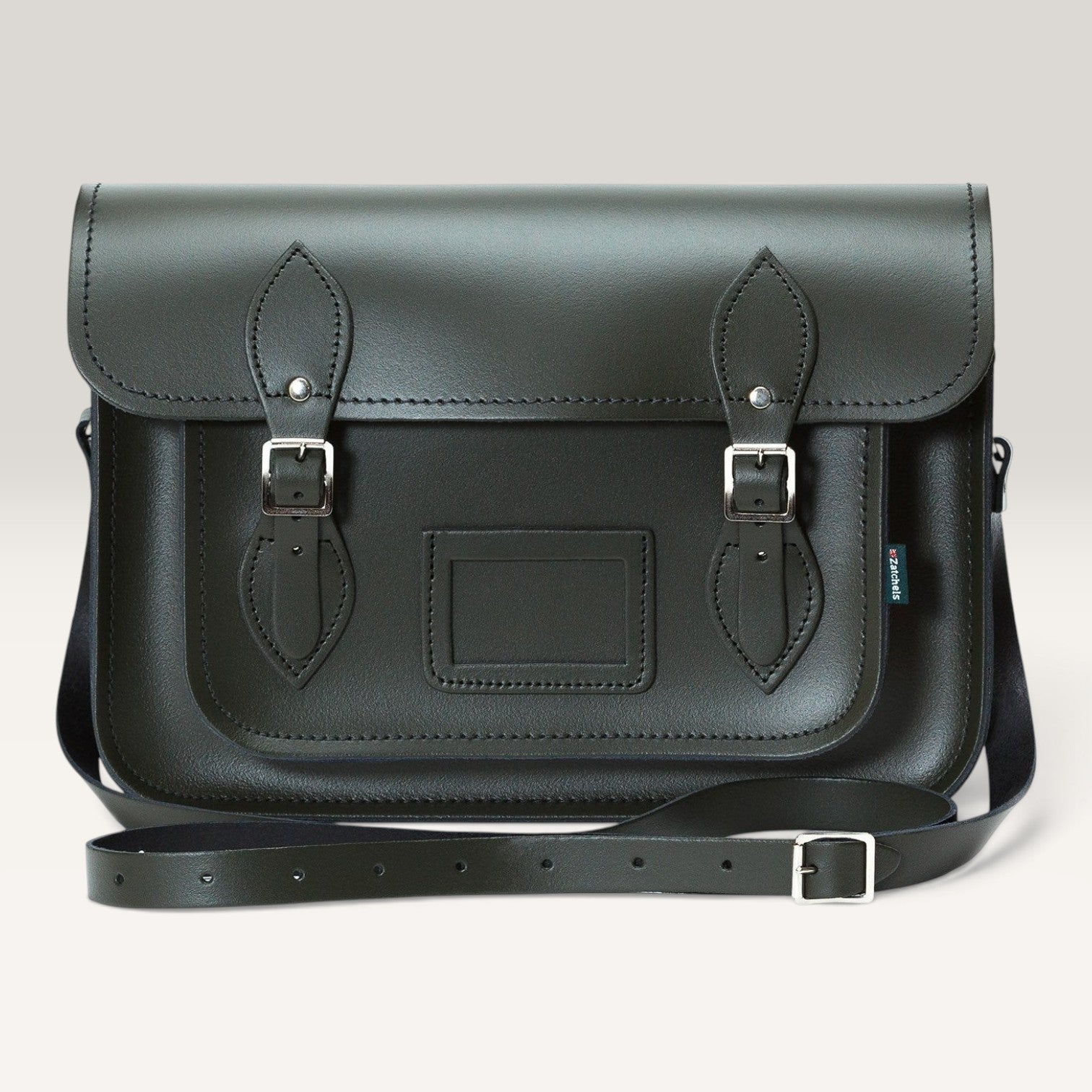 A dark green leather satchel bag with two buckle straps on the front flap, a rectangular patch pocket, and a detachable shoulder strap, shown against a light gray background.