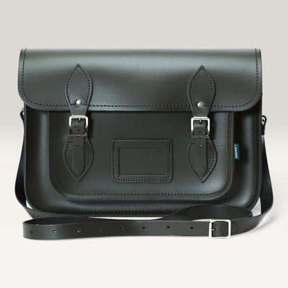 A dark green leather satchel bag with two buckle straps on the front flap, a rectangular patch pocket, and a detachable shoulder strap, shown against a light gray background.
