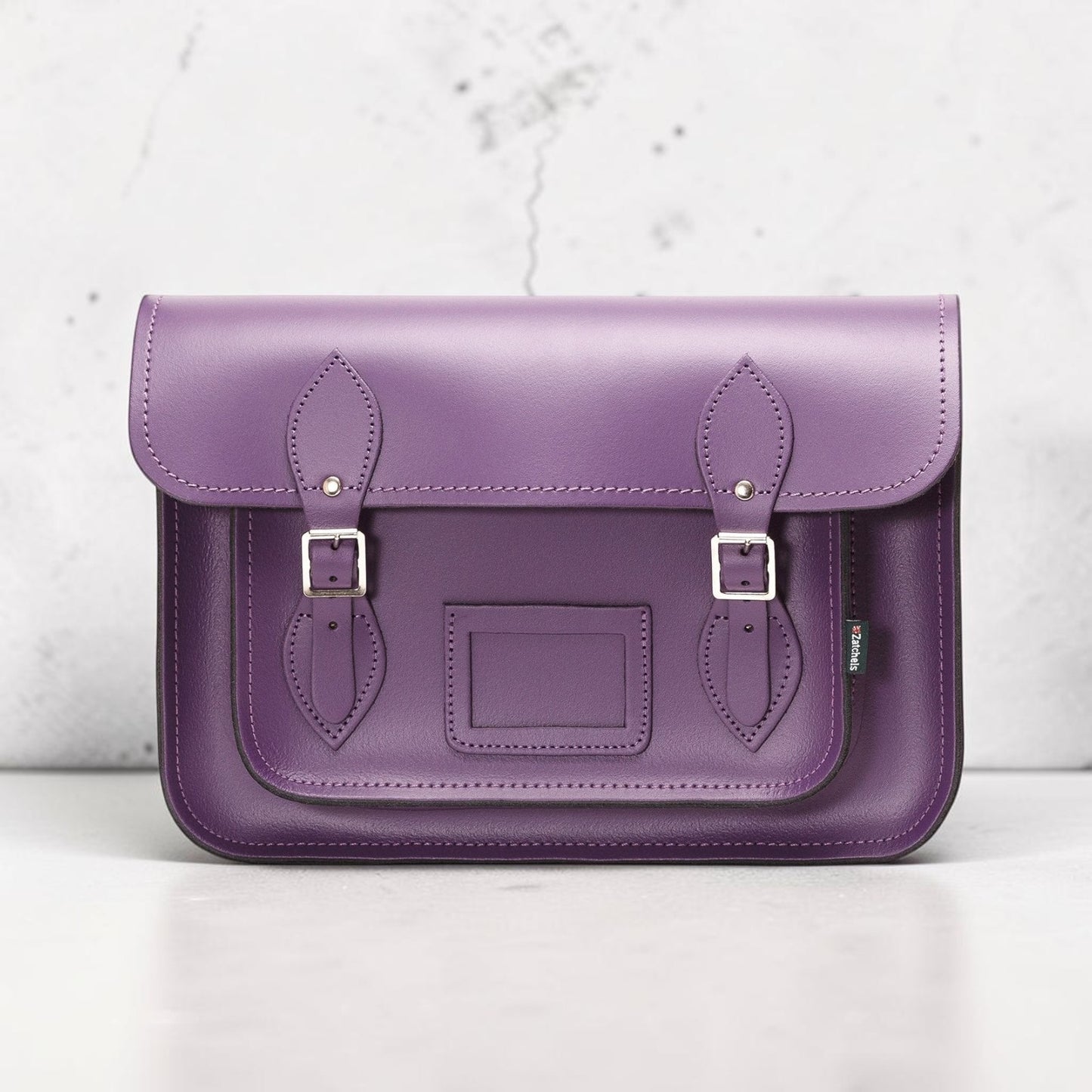 Purple leather satchel bag on a white background