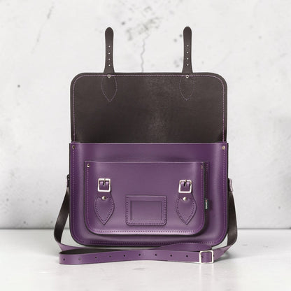 Purple leather bag with black interior on a light gray background