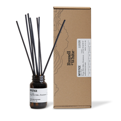 Diffuser bottle with black sticks and cardboard box labeled 'Opulence' on a white background