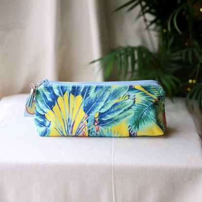 Palm Springs velvet pencil case with a pale blue zip and blue tassel on a cream cloth beside a palm plant
