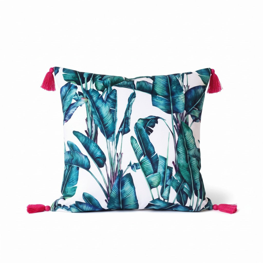 Rainforest velvet cushion with raspberry tassels, front view on a white background showing the green and teal banana leaf print, handmade in Dorset by Apricot Moon