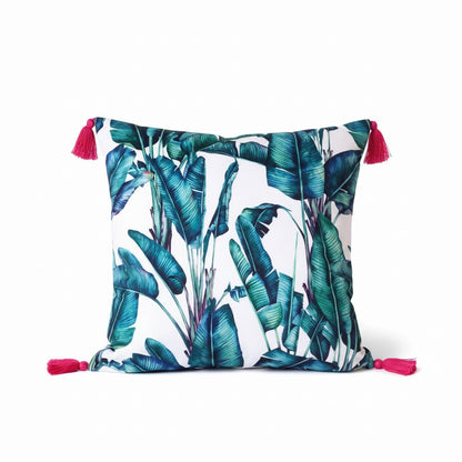 Rainforest velvet cushion with raspberry tassels, front view on a white background showing the green and teal banana leaf print, handmade in Dorset by Apricot Moon