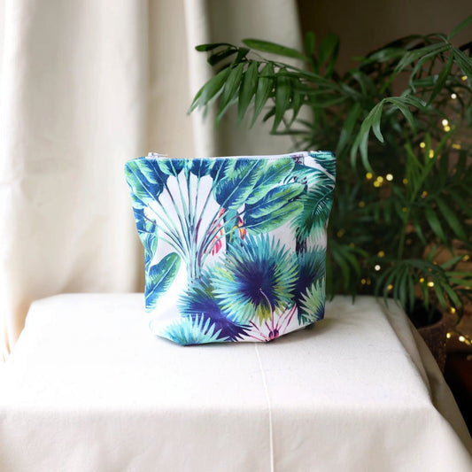 Rainforest Velvet wash bag with a white zip, front view on white cotton fabric beside a green palm plant with twinkling lights, handmade in Dorset by Apricot Moon