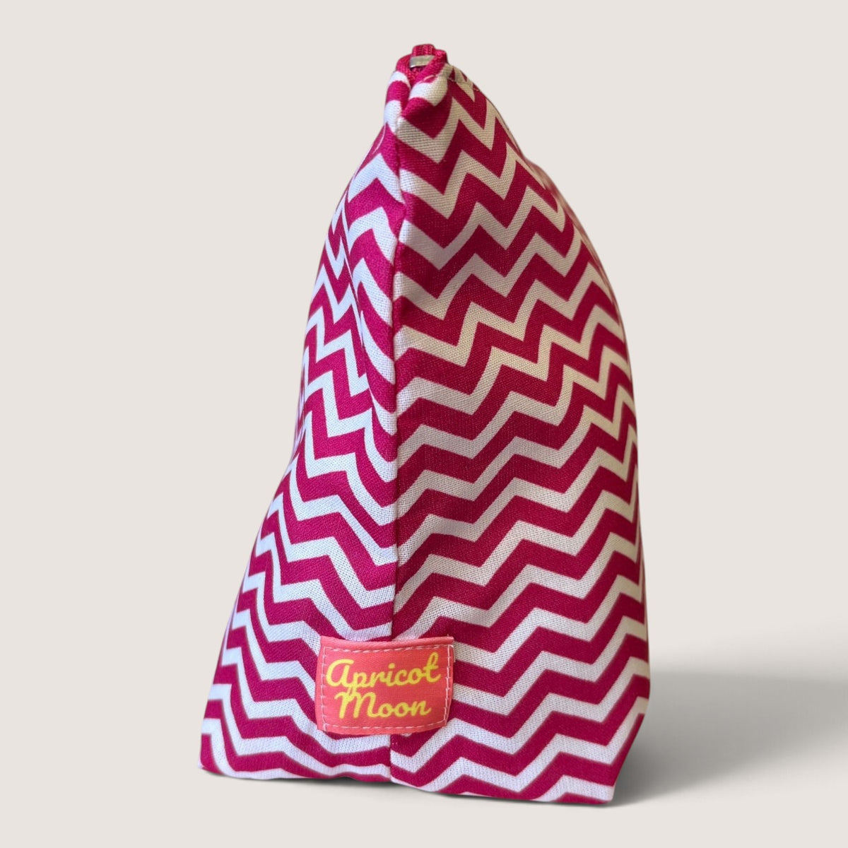 End view of the Raspberry Chevron wash bag showing the Apricot Moon label