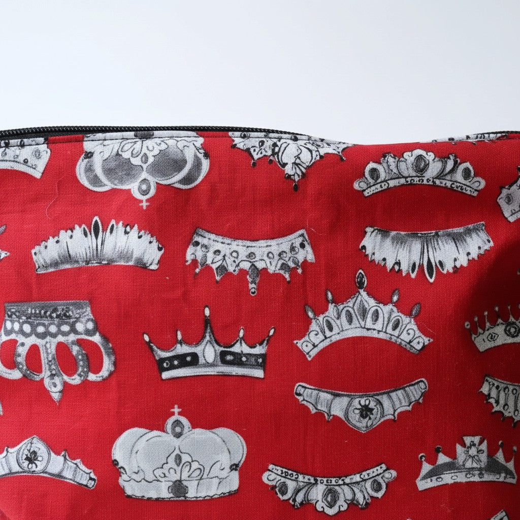Close-up of the Red Crowns fabric on the front of the everyday pouch, grey and white crowns and tiaras on bright red cotton