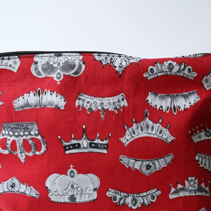 Close-up of the Red Crowns fabric on the front of the everyday pouch, grey and white crowns and tiaras on bright red cotton