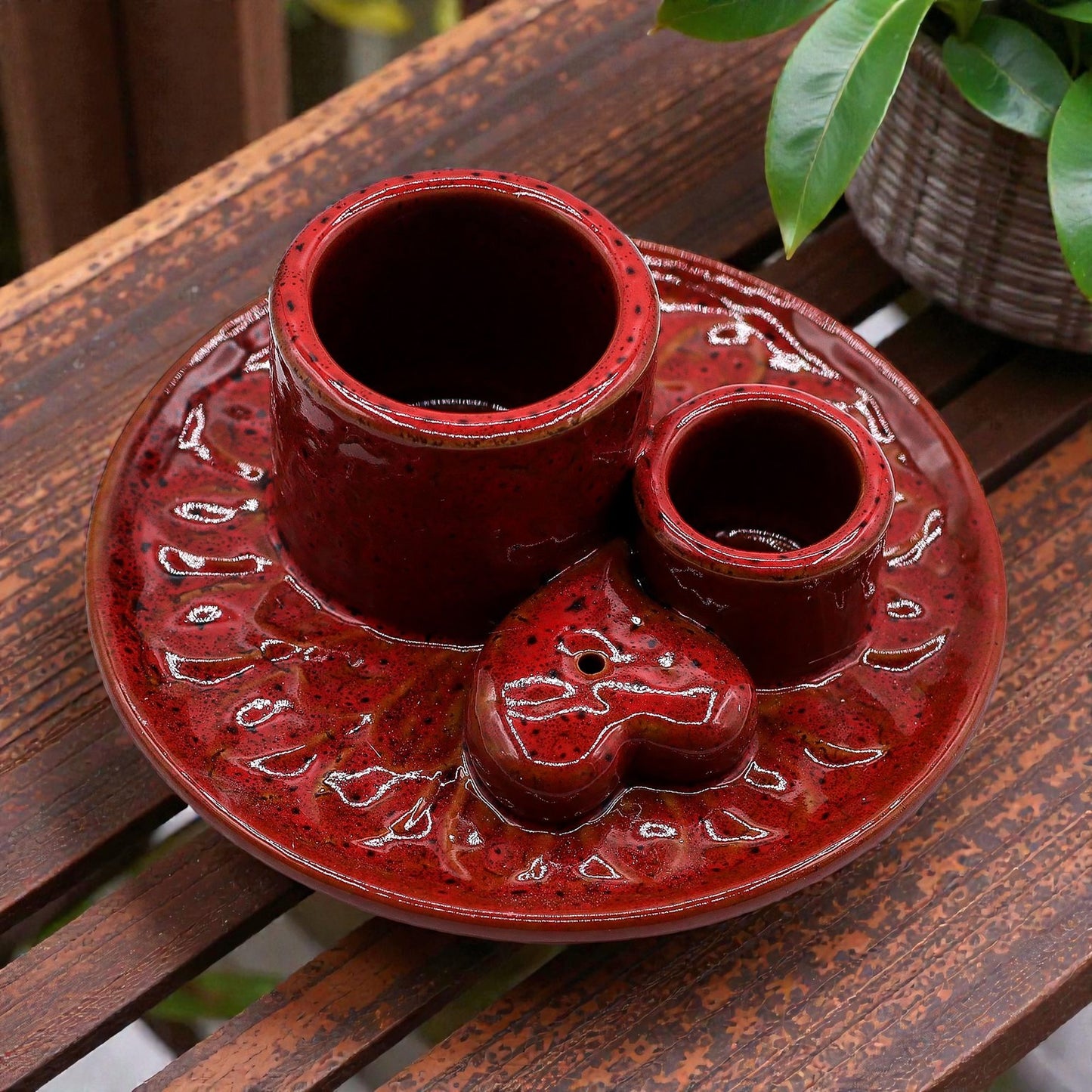 Red ceramic incense and smudge stick burner with three compartments on a wooden surface