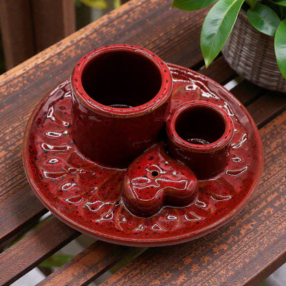 Red ceramic incense and smudge stick burner with three compartments on a wooden surface