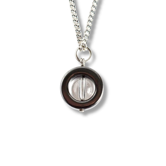 Silver necklace with a round pendant on a white background