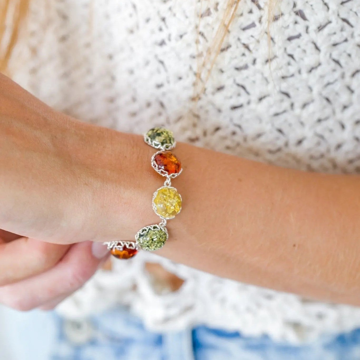 Bracelet with colorful beads on a wrist against a textured background