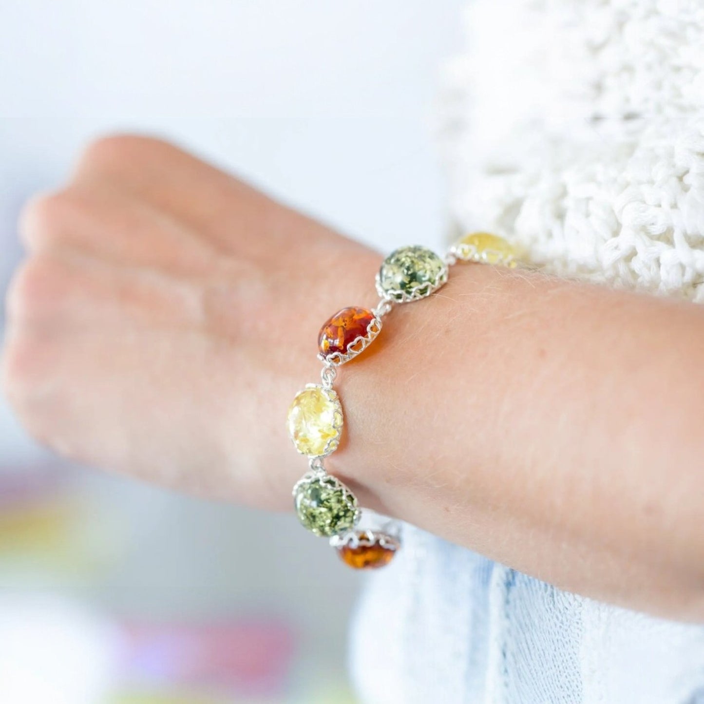 Close-up of a wrist wearing a bracelet with colorful beads on a blurred background