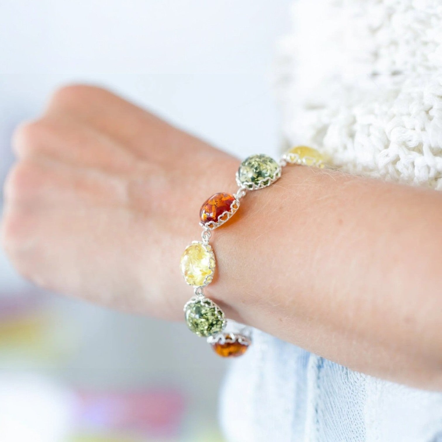 Close-up of a wrist wearing a bracelet with colorful beads on a blurred background