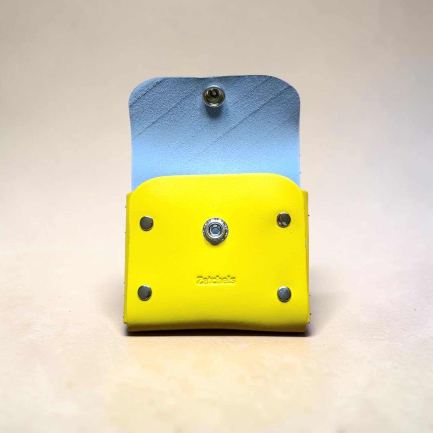 Two-layered tool holder with blue top and yellow bottom on a light gray background