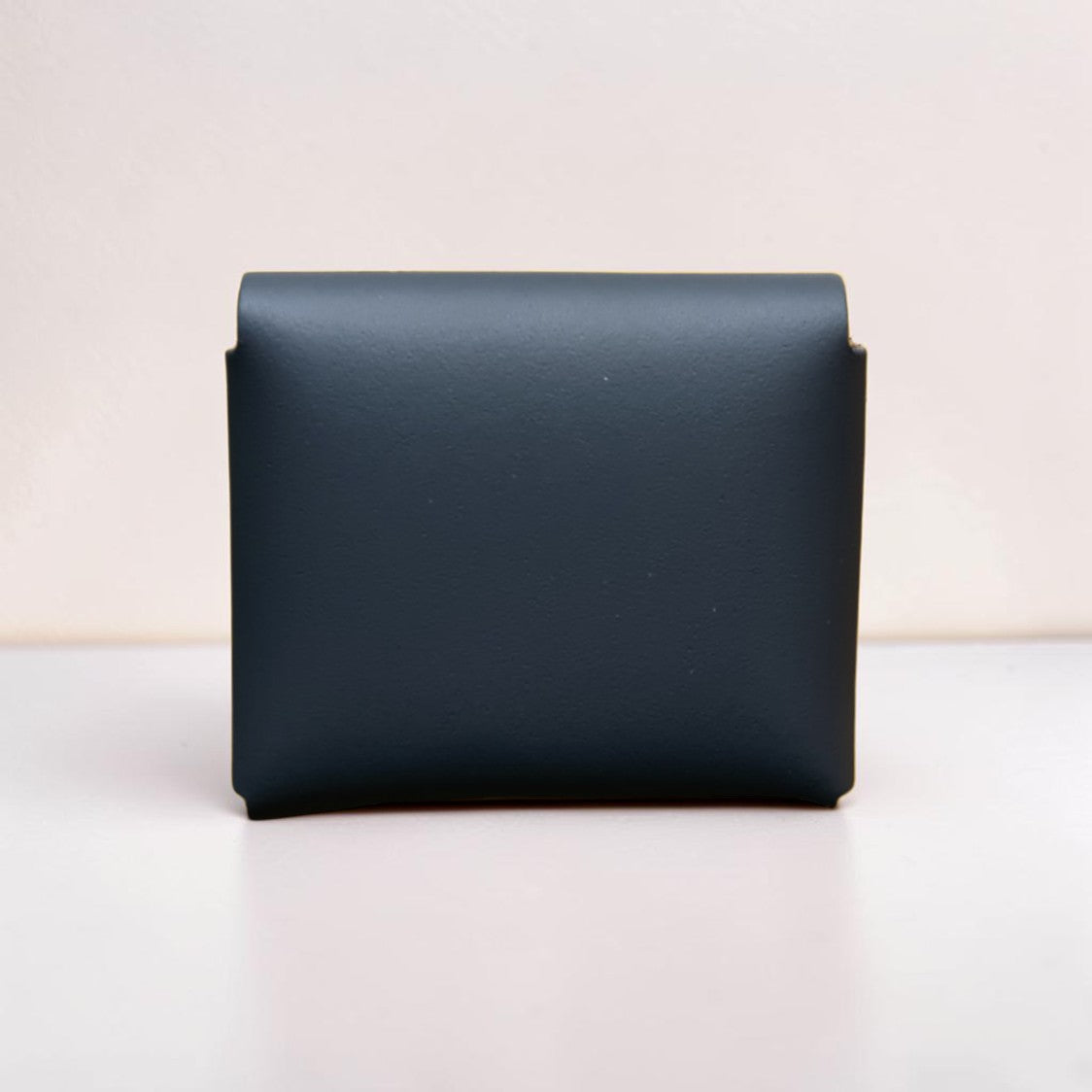 Black leather wallet on a light beige background