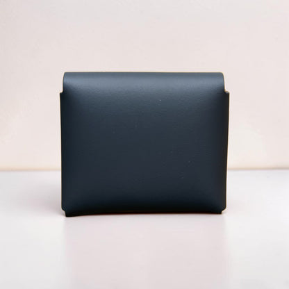 Black leather wallet on a light beige background