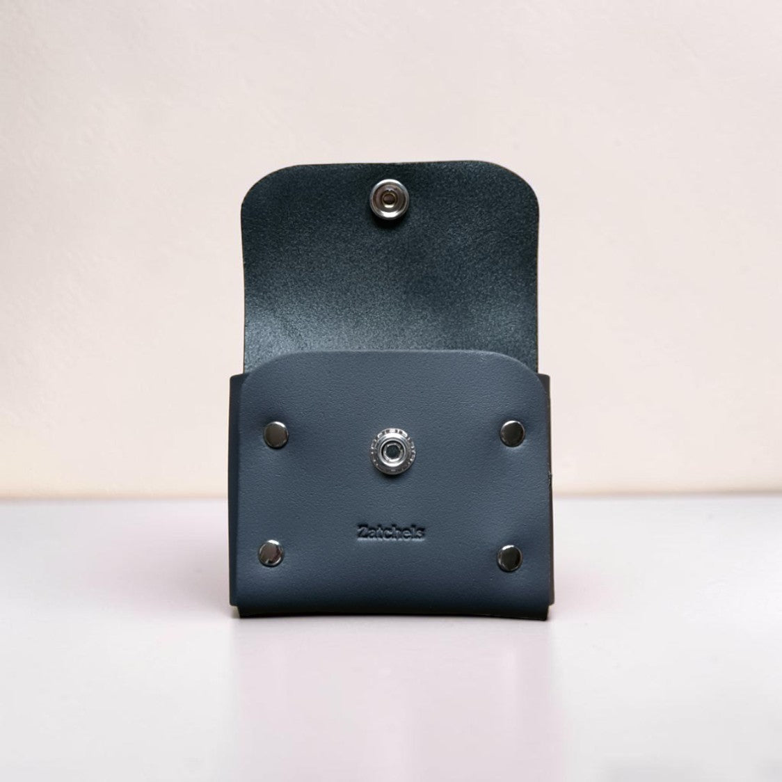 Blue leather wallet with metal fastenings on a light background