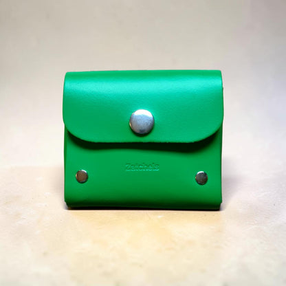 Green leather wallet with silver buttons on a light background