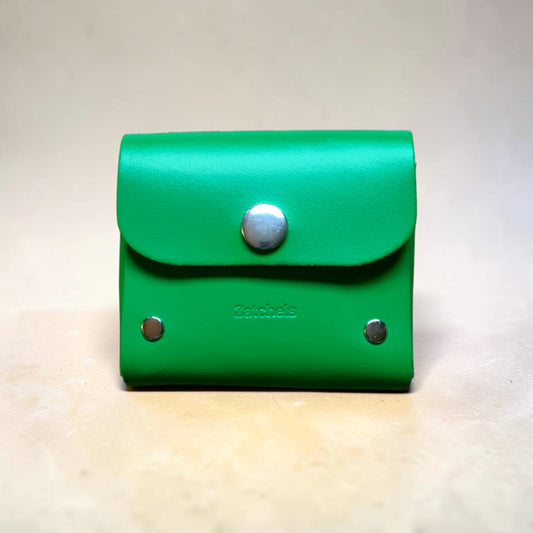 Green leather wallet with silver buttons on a light background