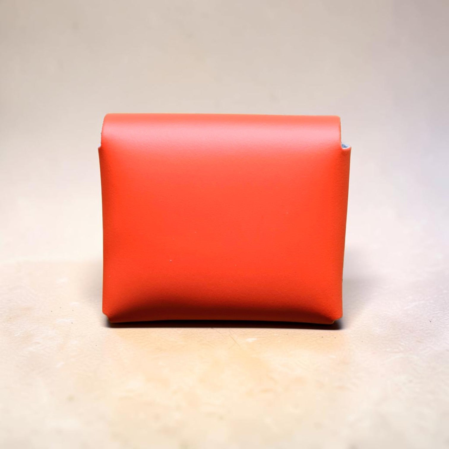 Red leather wallet on a light wooden surface