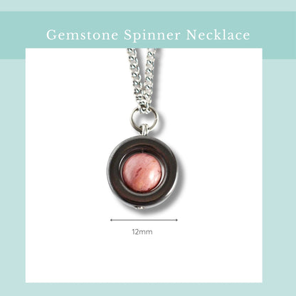 Gemstone spinner necklace with pink gemstone on a white background