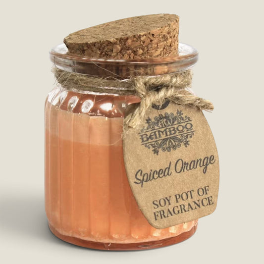 Spiced Orange soy candle in a ribbed glass jar with a cork lid and jute-tied kraft tag, on a plain background