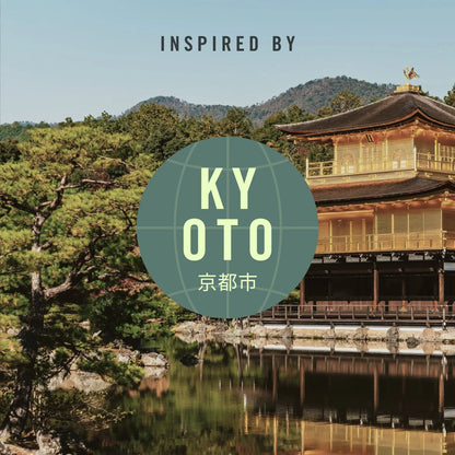 A travel-inspired graphic featuring a Japanese temple by a reflective pond, with trees, mountains, and a blue sky in the background. Large text reads 'INSPIRED BY' at the top, and a teal circular badge in the center says 'KYOTO' with Japanese characters below.