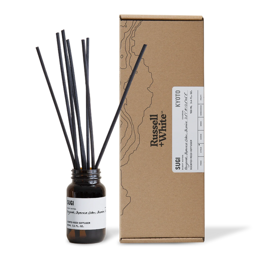Diffuser bottle with black sticks and cardboard box labeled 'Russell White' on a white background