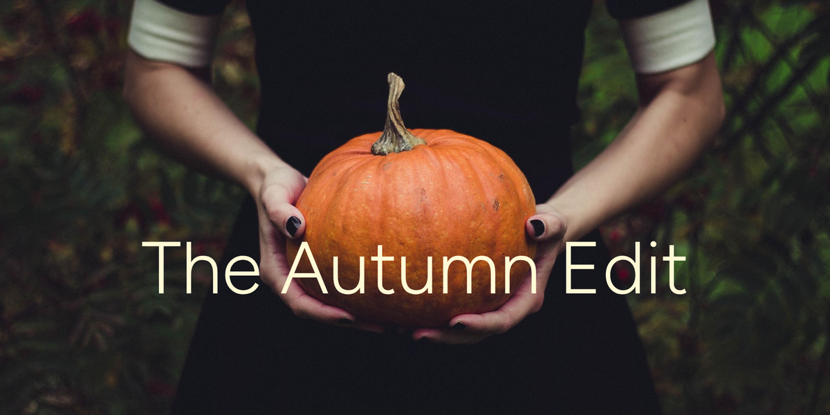 “The Autumn Edit” collection banner: hands with black nail polish holding an orange pumpkin against a dark autumn background