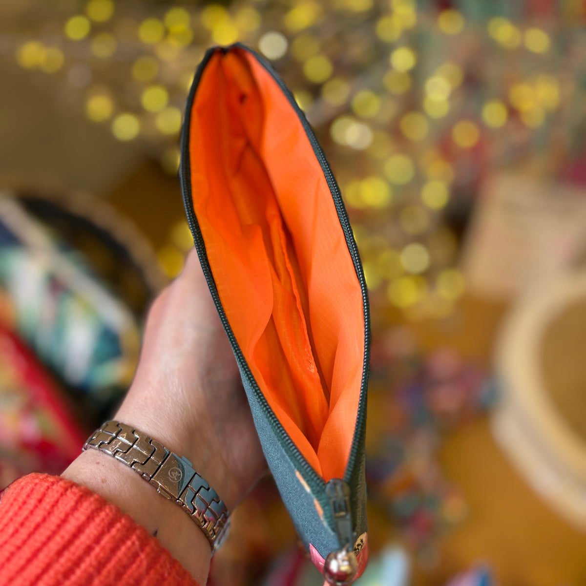 Tiger Tiger pencil case held open to show the bright orange Apricot Moon lining and a dark green zip