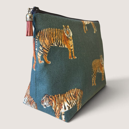 Tiger Tiger wash bag in a tiger print on deep teal, with a black zip and dusky pink suede tassel, angled view