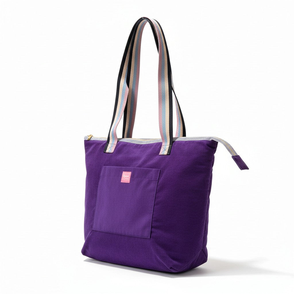 Angled view of the Twilight Bloom purple corduroy shoulder tote with striped handles and a front pocket, on a white background
