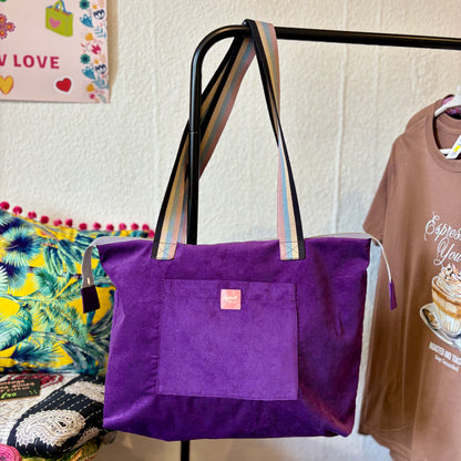 Twilight Bloom purple corduroy shoulder tote hanging by its handles on a clothes rail in the Apricot Moon shop