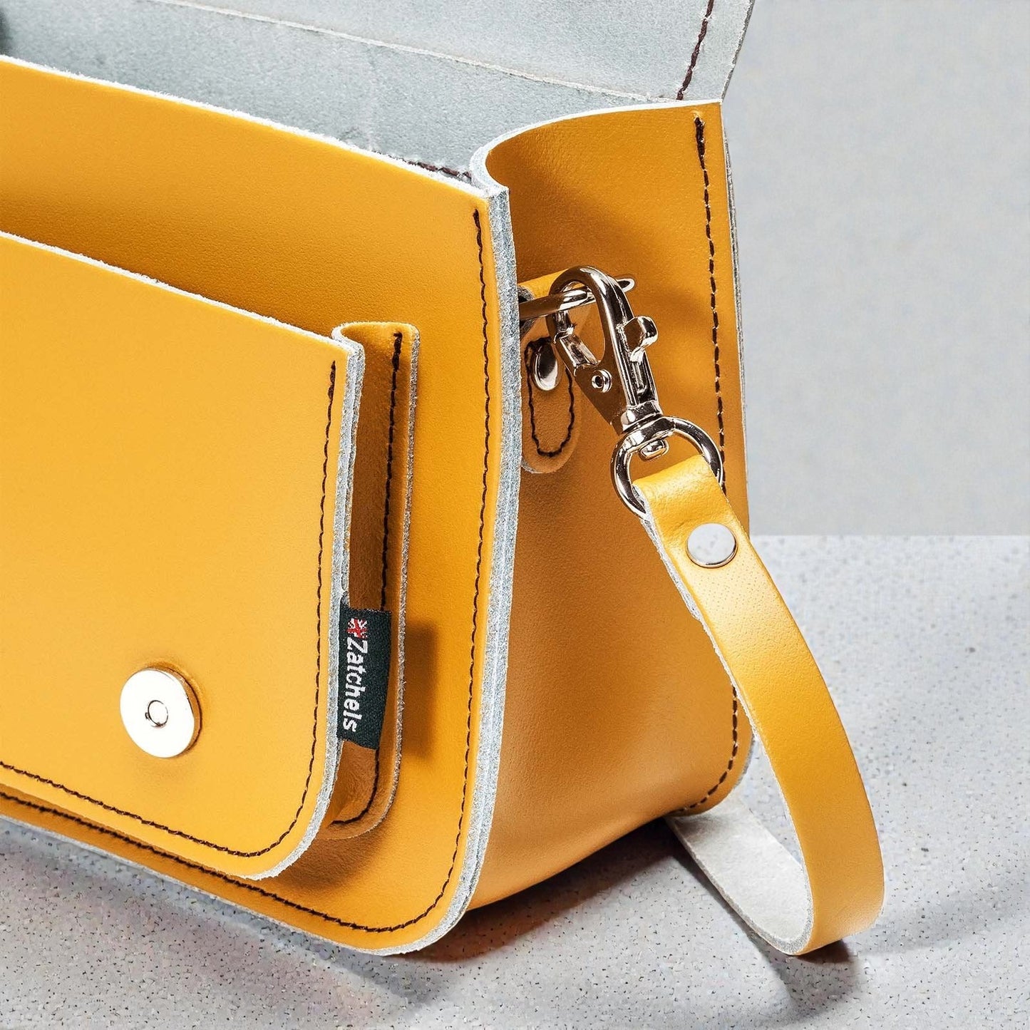 Yellow handbag with a strap on a light gray background