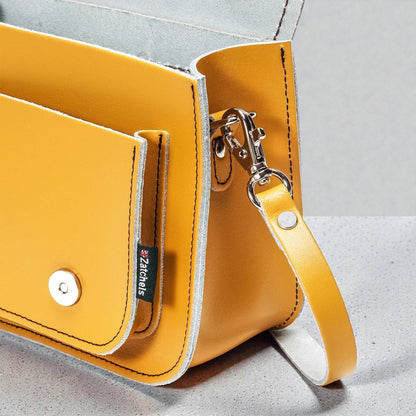 Yellow handbag with a strap on a light gray background