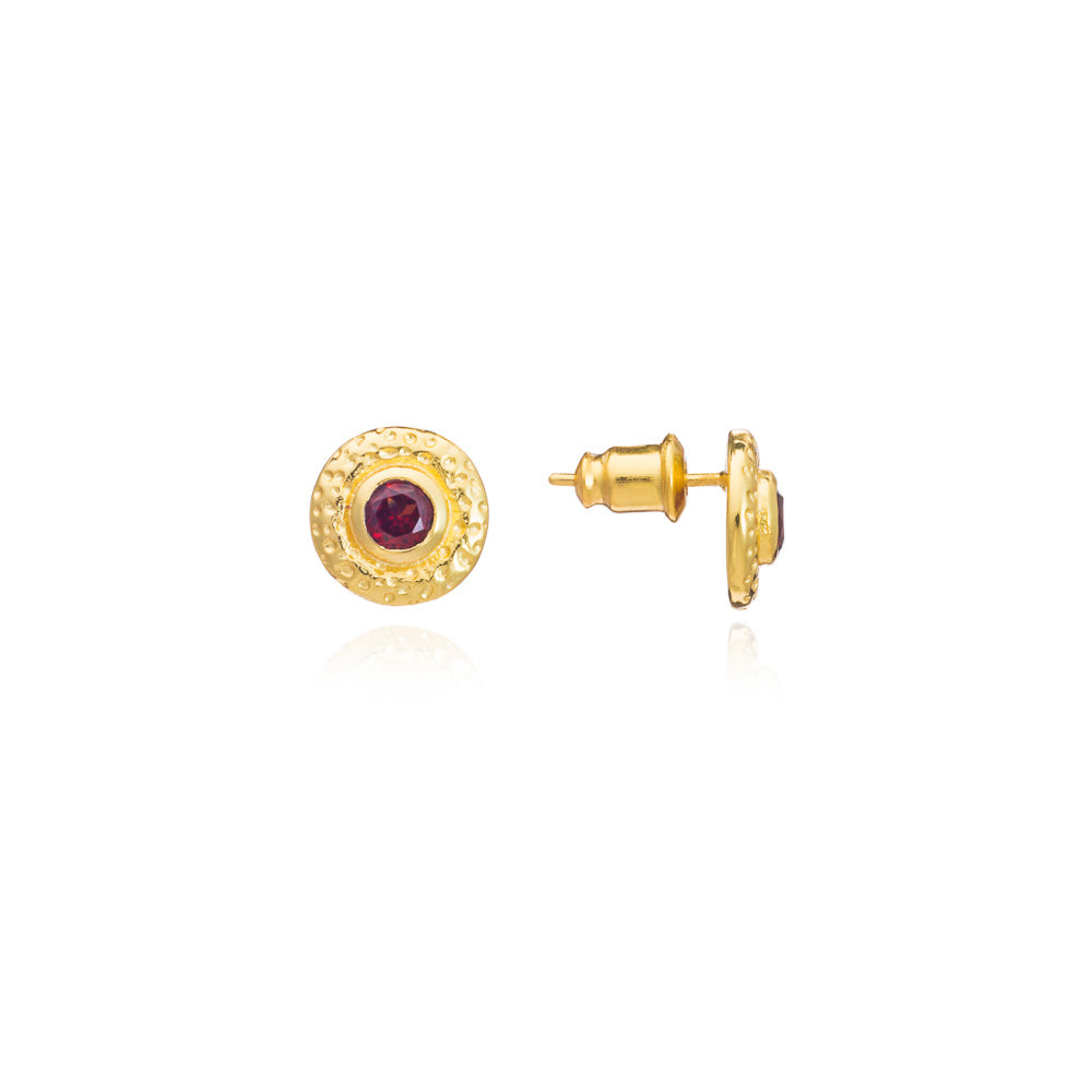 Gold earrings with a red gemstone on a white background