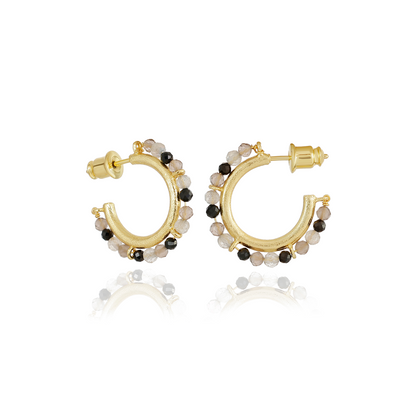 Gold hoop earrings with black and white bead accents on a white background
