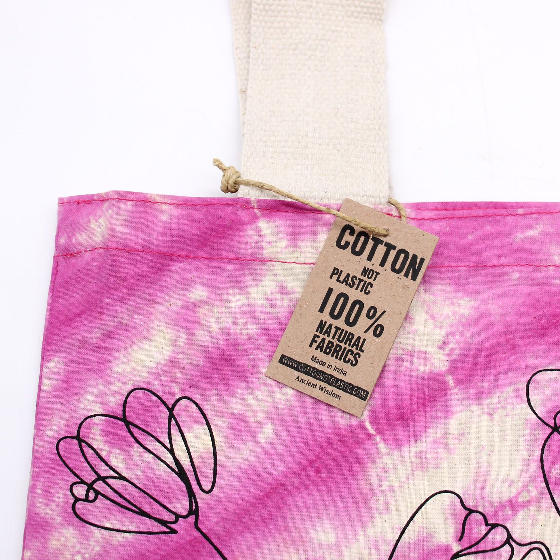 Pink tie-dye tote bag with a tag indicating 'Cotton Not Plastic' and '100% Natural Fabrics'.