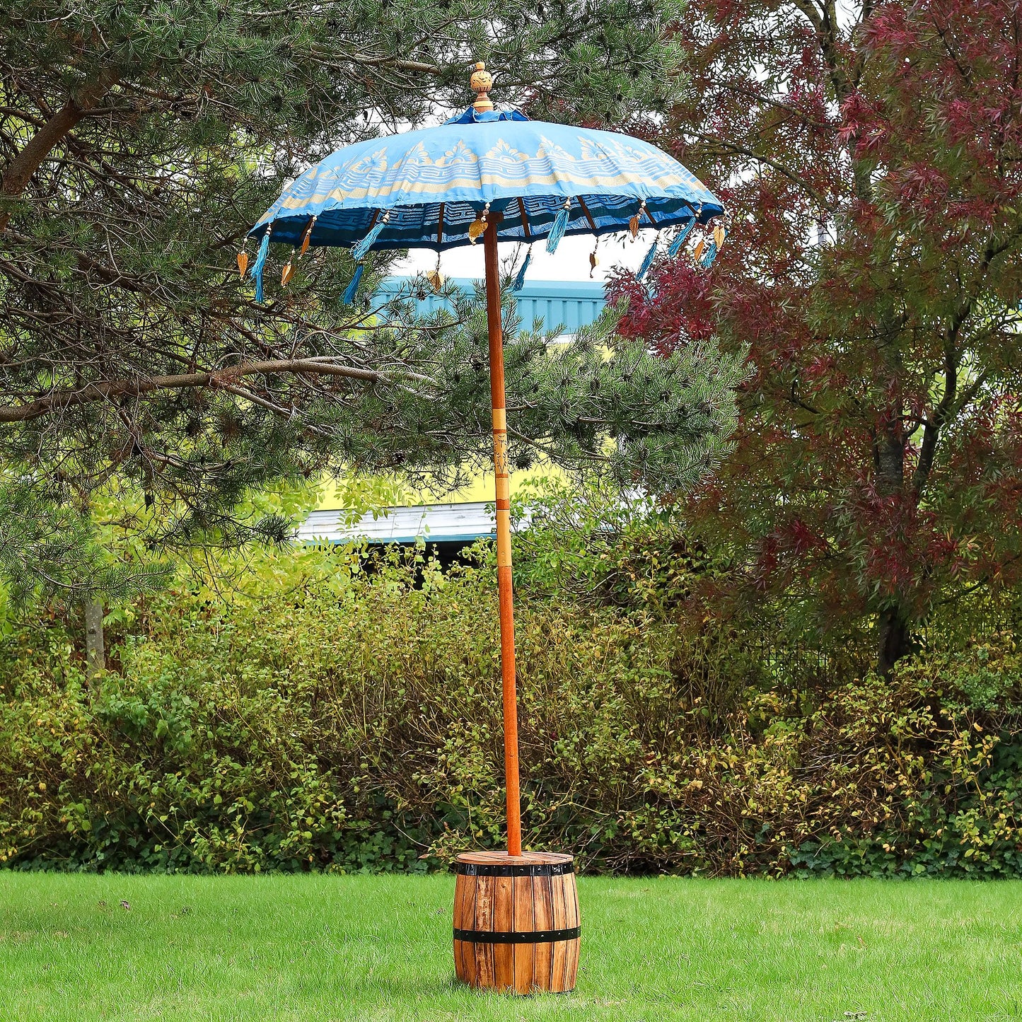 Decorative outdoor umbrella with wooden base in a garden setting