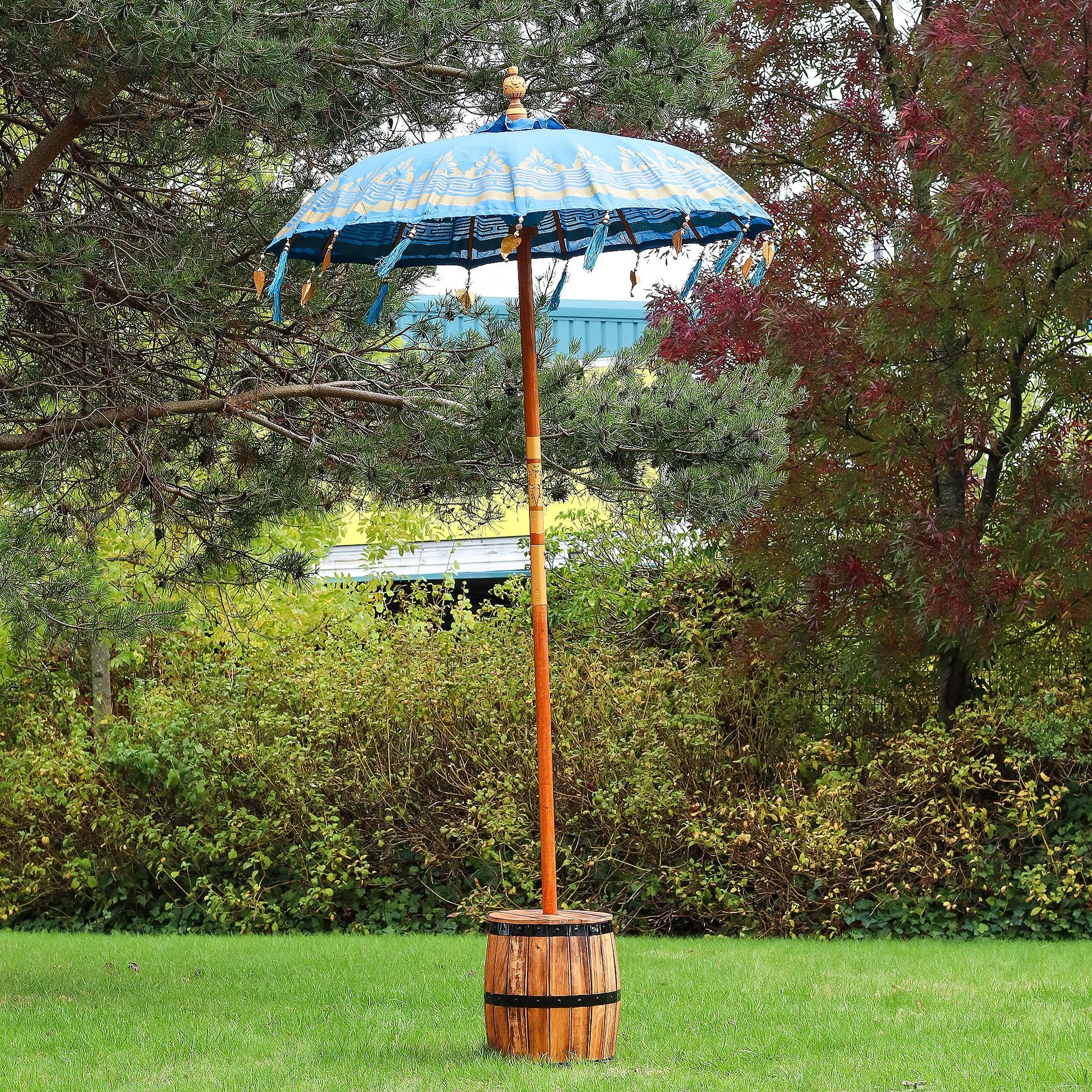 Decorative outdoor umbrella with wooden base in a garden setting