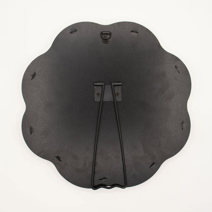 Black metal wall art piece with decorative design on a white background