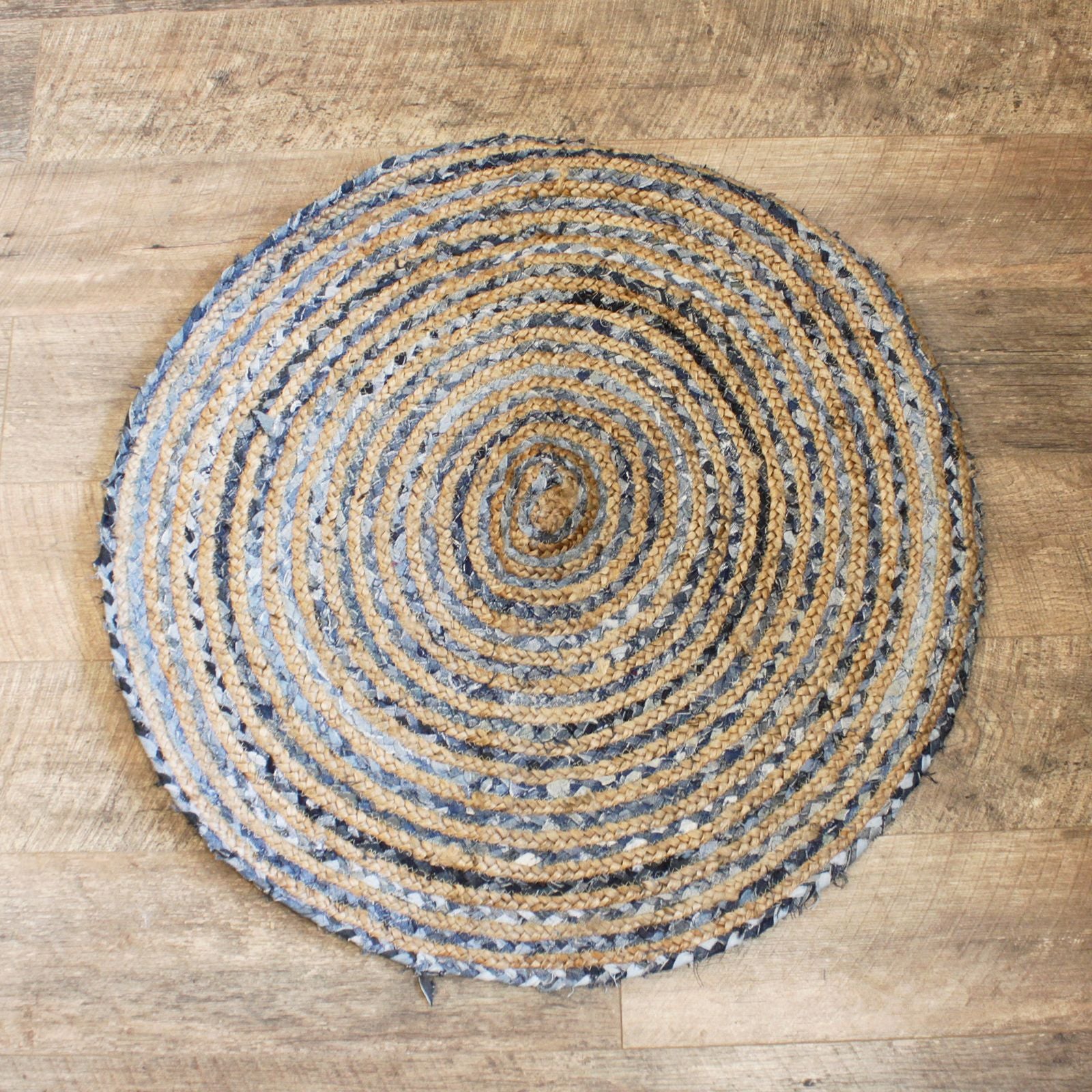 Round woven rug with concentric circles on a wooden floor