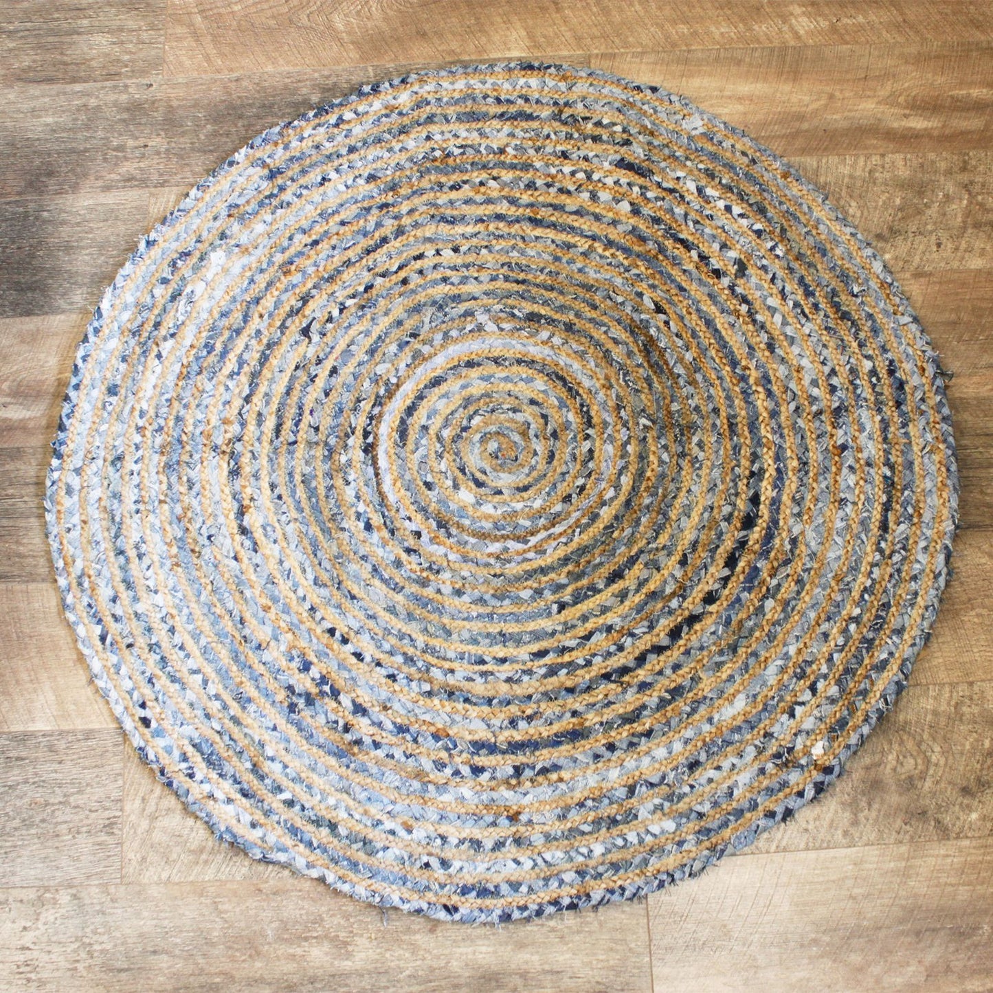Round woven rug with concentric circle pattern on a wooden floor