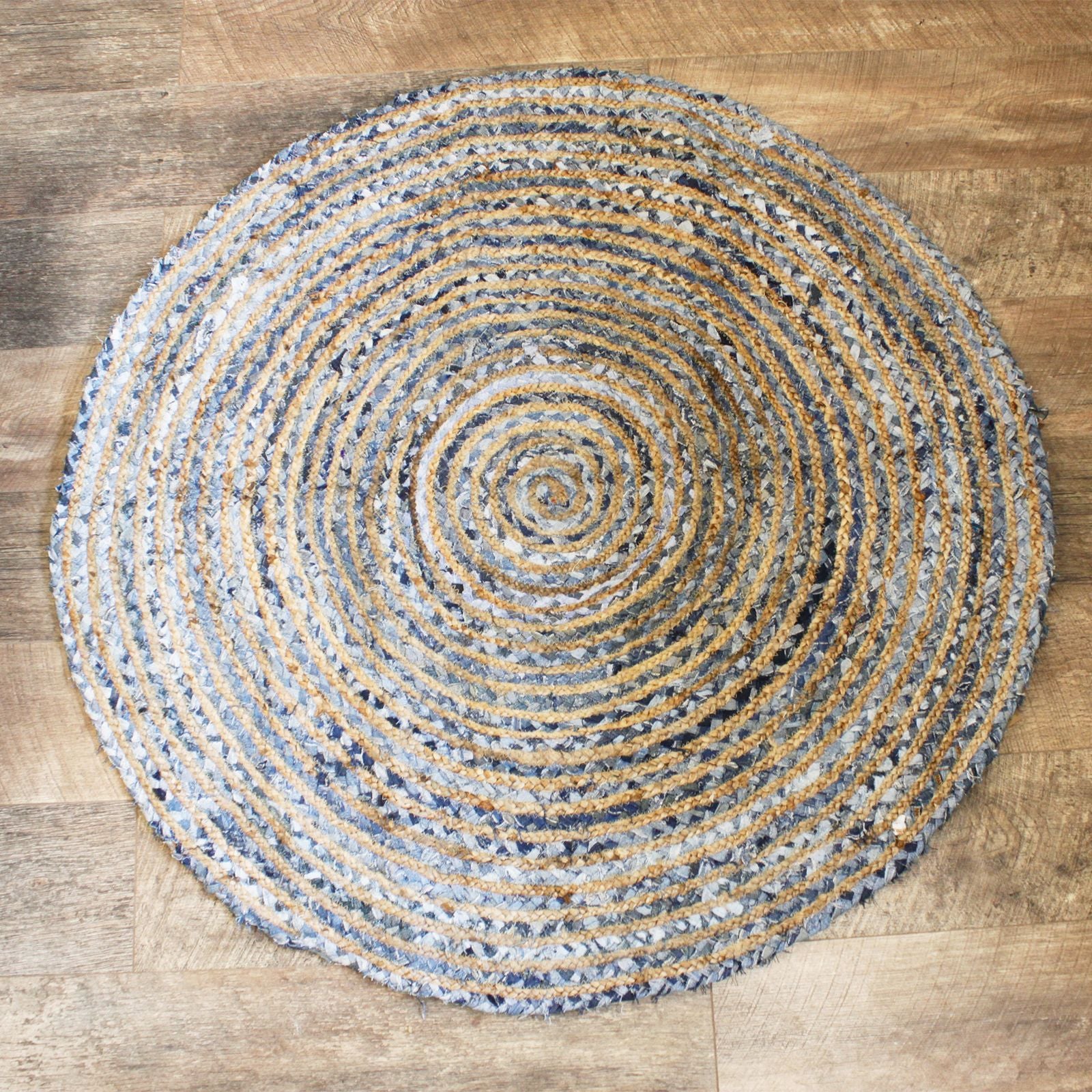 Round woven rug with concentric circle pattern on a wooden floor